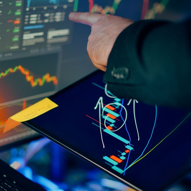 A hand pointing at a chart on a tablet